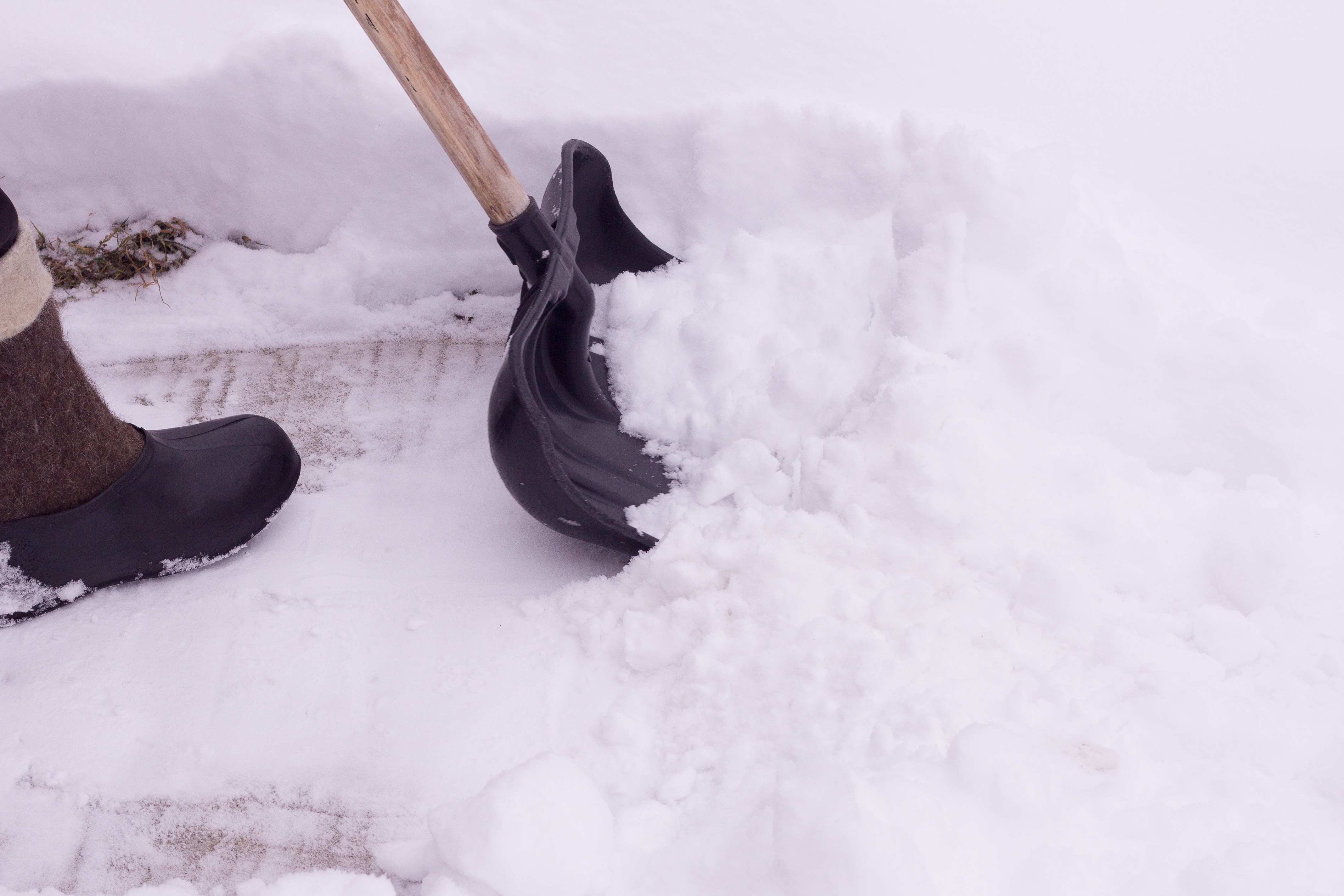 A,Man,Cleans,Snow,From,The,Sidewalk,In,Front,Of A,Man,Cleans,Snow,From,The,Sidewalk,In,Front,Of