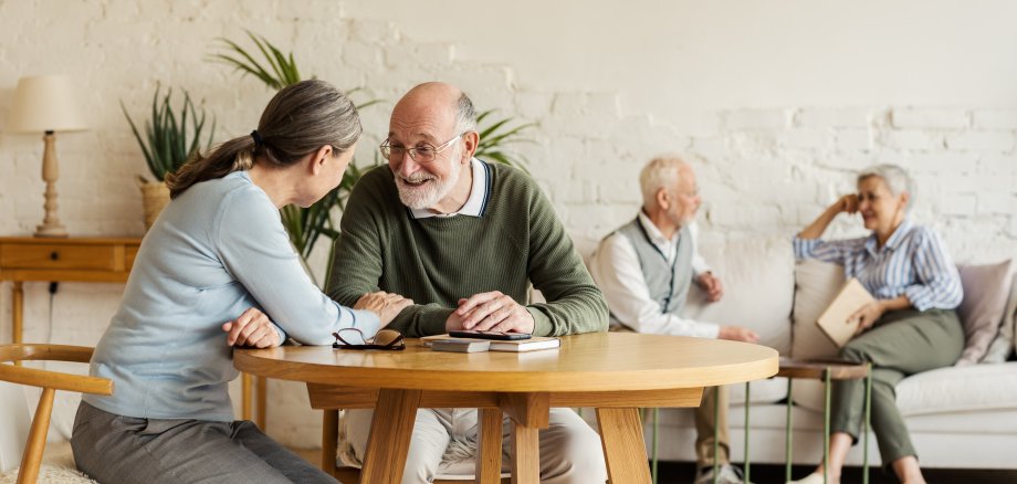 Elderly,Man,And,Woman,Sitting,At,Table,And,Enjoying,Joyful