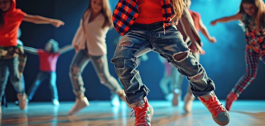 Happy children in stylish clothes dancing in choreography class