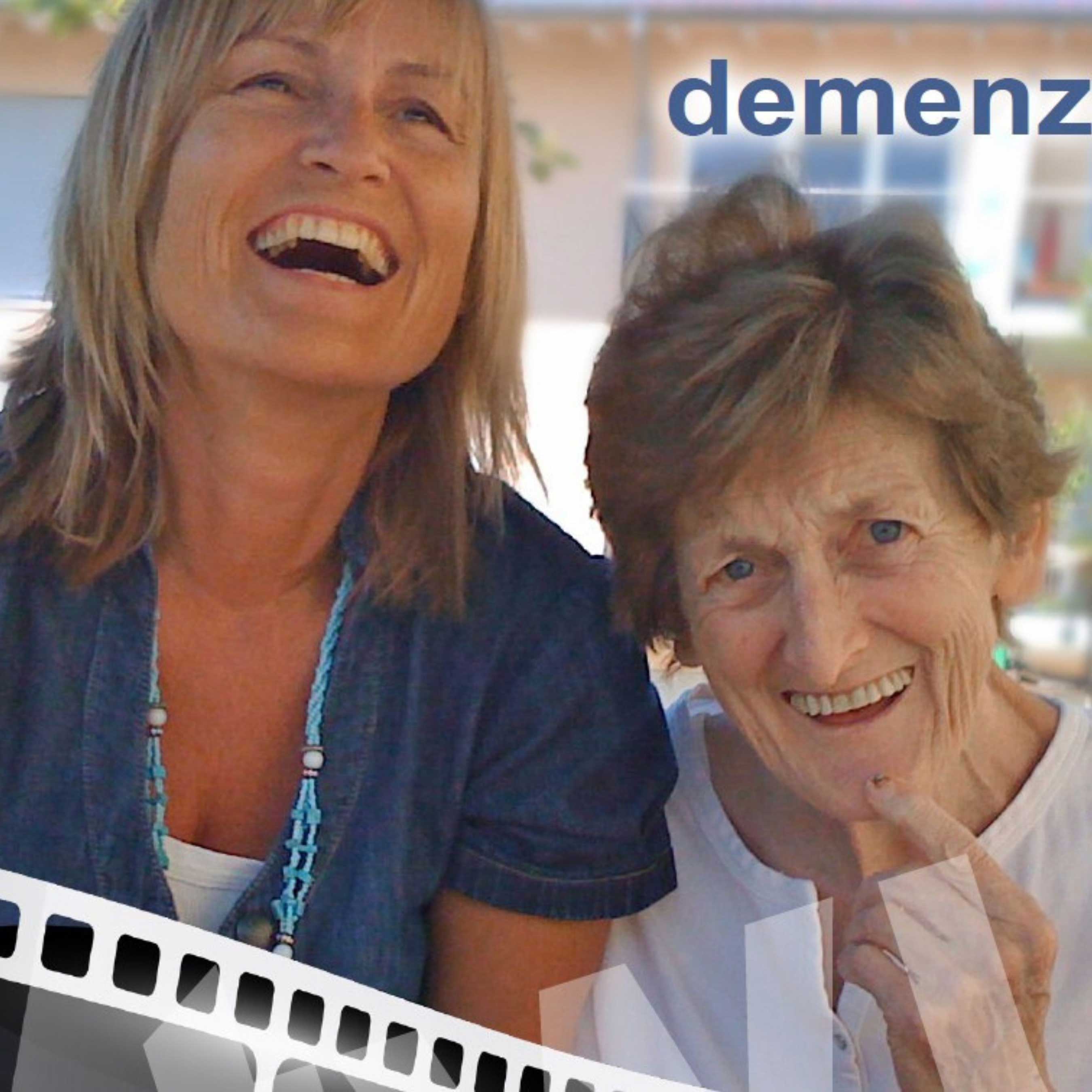 Zwei Frauen sitzen lachend nebeneinander und strahlen Lebensfreude aus. Das Wort „Demenz“ steht oben im Bild – es vermittelt Nähe, Verständnis und Menschlichkeit im Umgang mit Demenzbetroffenen.