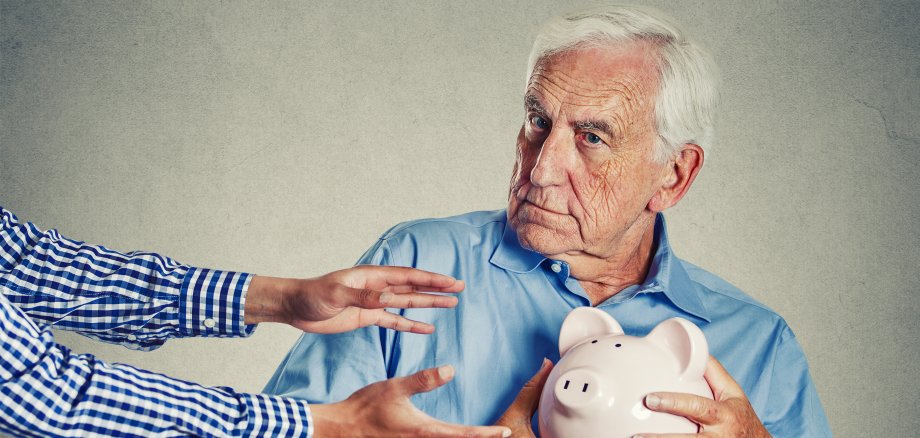 Closeup,Portrait,Senior,Man,Grandfather,Holding,Piggy,Bank,Looking,Suspicious