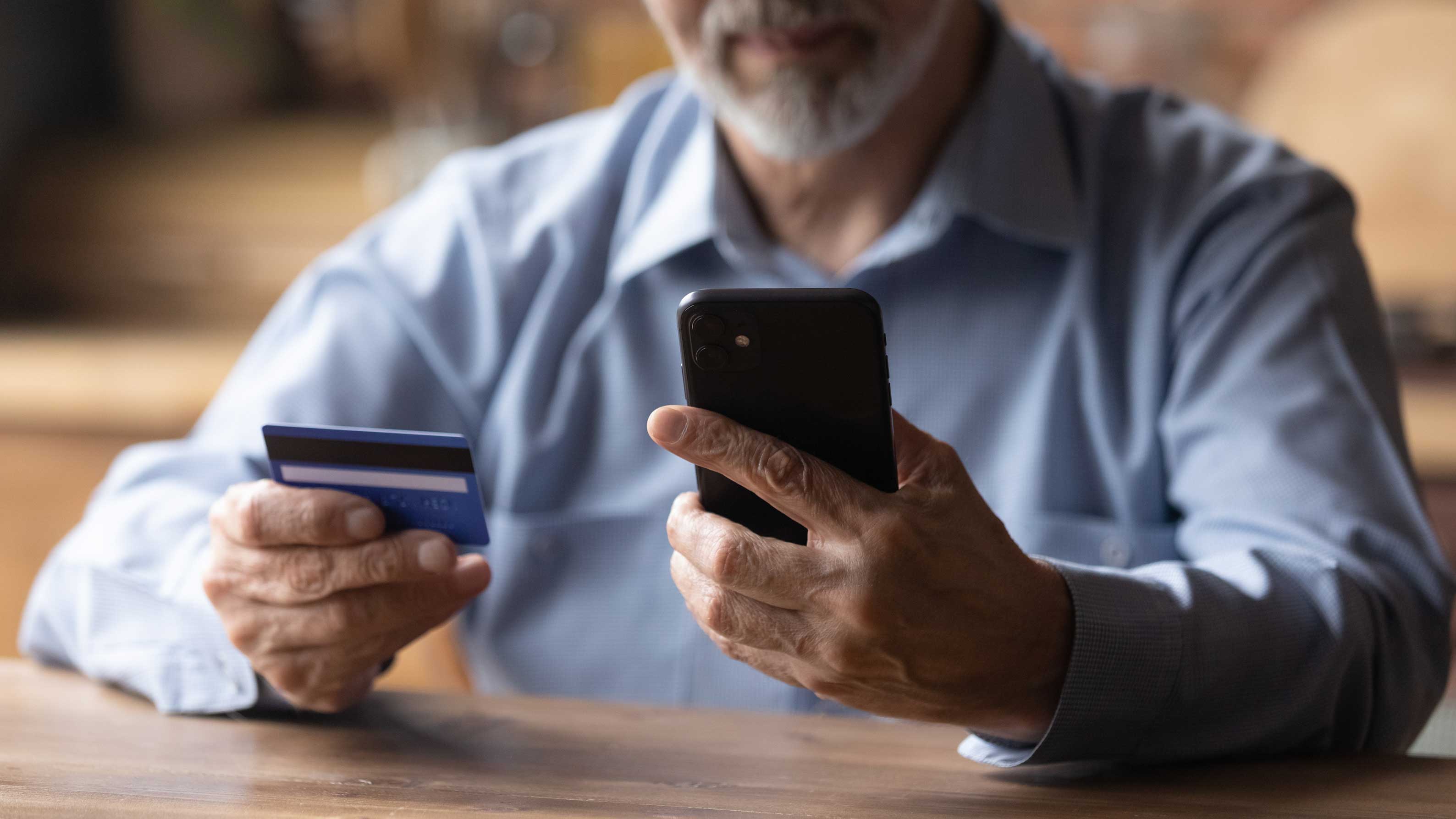 Close,Up,Mature,Man,Using,Phone,,Holding,Plastic,Credit,Or Close,Up,Mature,Man,Using,Phone,,Holding,Plastic,Credit,Or