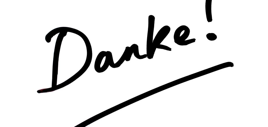 Das Wort "Danke!" ist in schwarzer, handgeschriebener Schrift mit einem Ausrufezeichen auf einem weißen Hintergrund dargestellt. Unter dem Wort befindet sich ein horizontaler Strich.