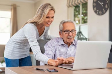 Senior,Man,And,Mature,Daughter,Smiling,And,Looking,At,Laptop Senior,Man,And,Mature,Daughter,Smiling,And,Looking,At,Laptop