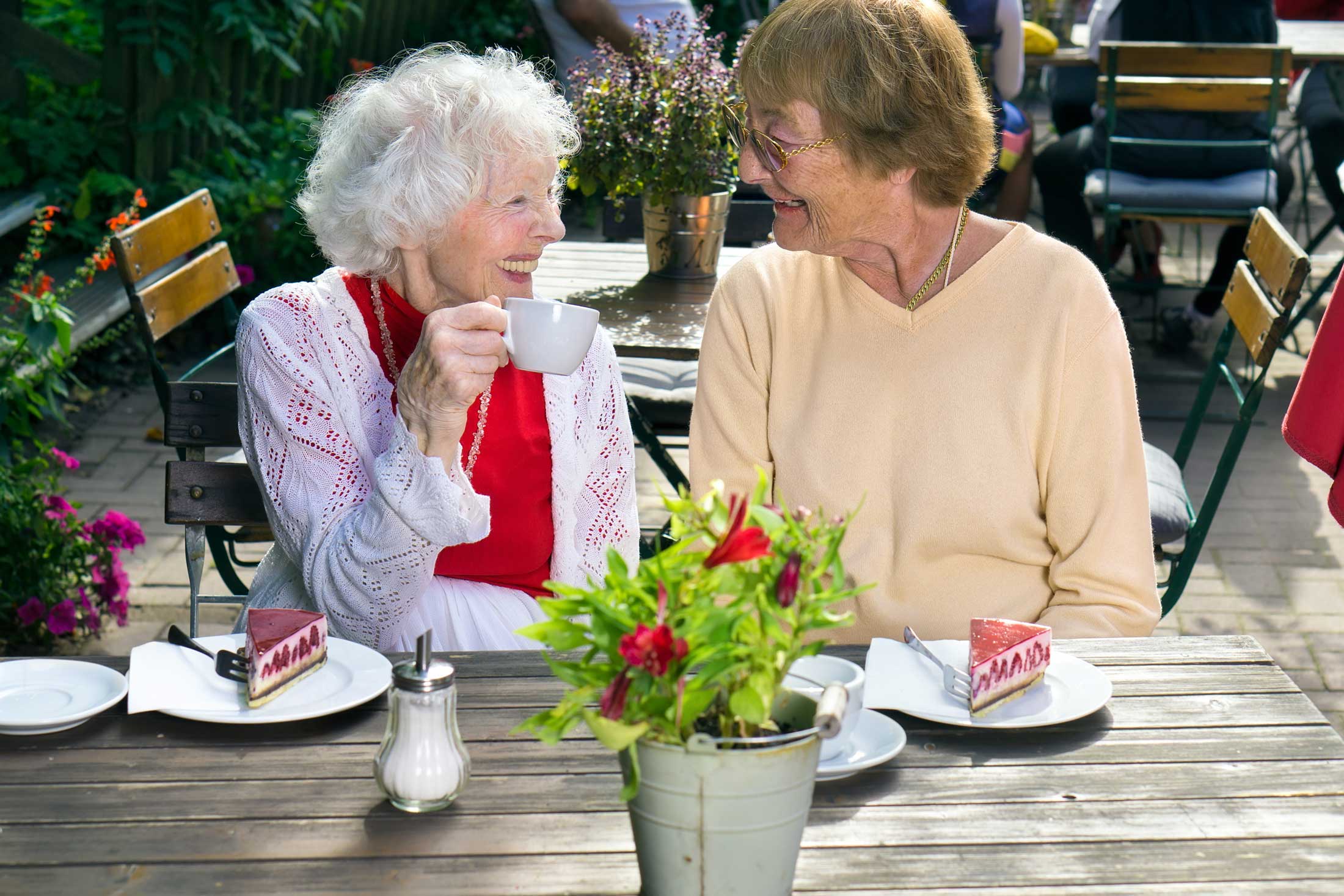 Two,Senior,Lady,Friends,Enjoying,Outdoor,Refreshments,Sitting,At,A Two,Senior,Lady,Friends,Enjoying,Outdoor,Refreshments,Sitting,At,A