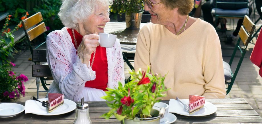 Two,Senior,Lady,Friends,Enjoying,Outdoor,Refreshments,Sitting,At,A