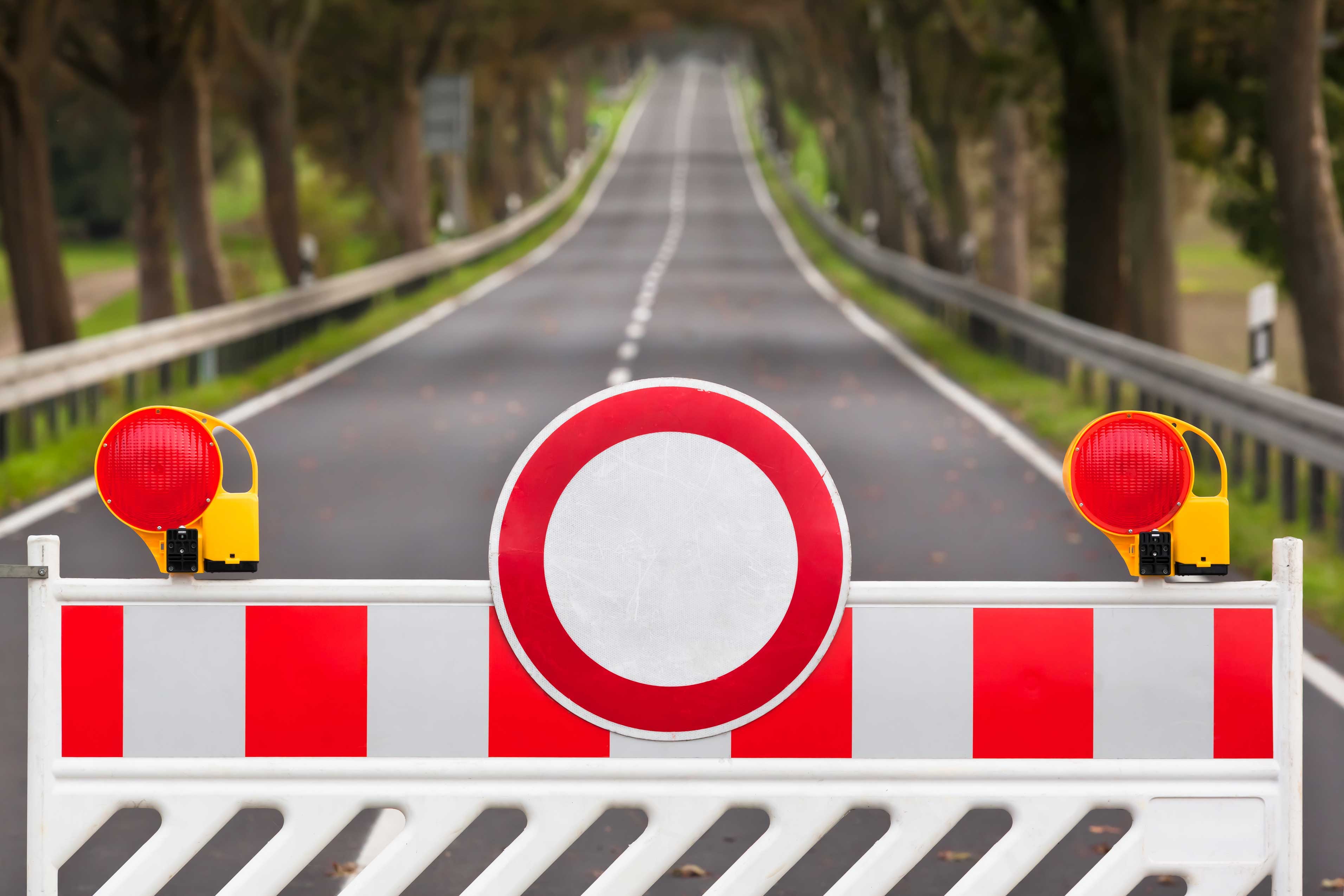 Red,And,White,Colored,Street,Barrier,At,An,Empty,Road/closed Red,And,White,Colored,Street,Barrier,At,An,Empty,Road/closed